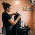 Estilista trabajando en el cabello de una clienta vista de espaldas.